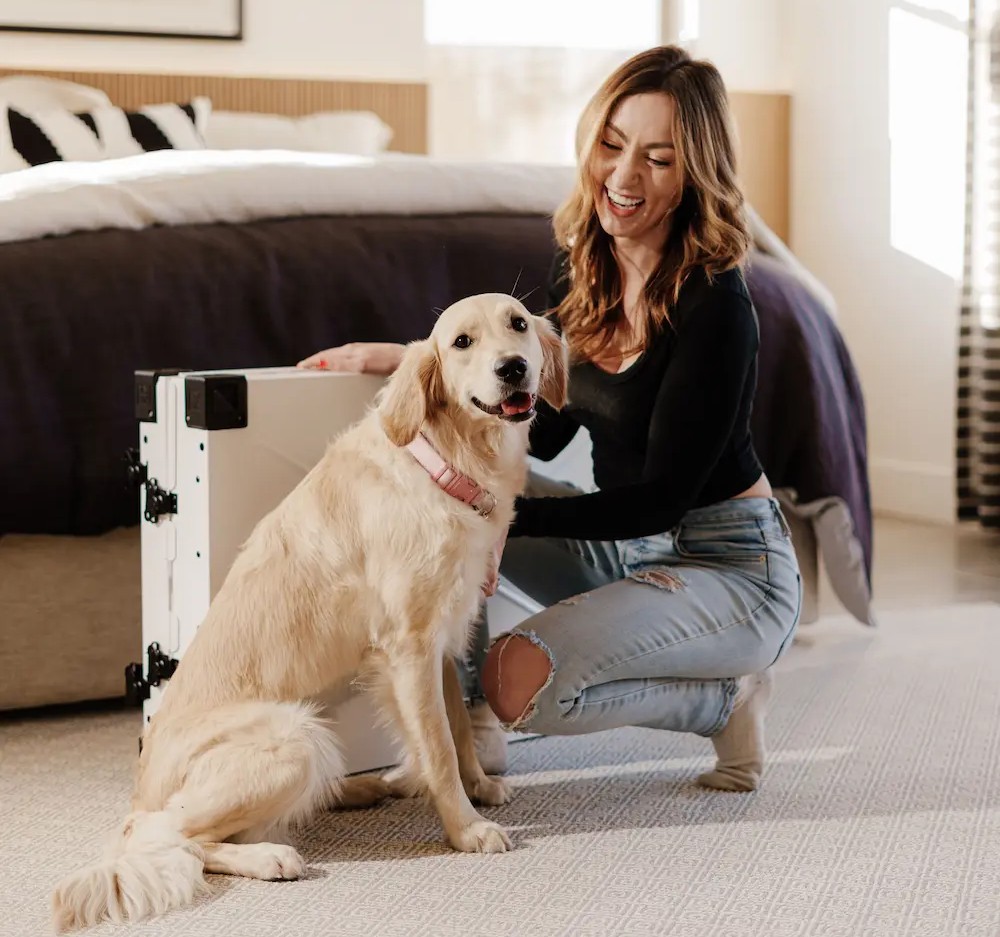 A dog and its owner next to a travel suitcase